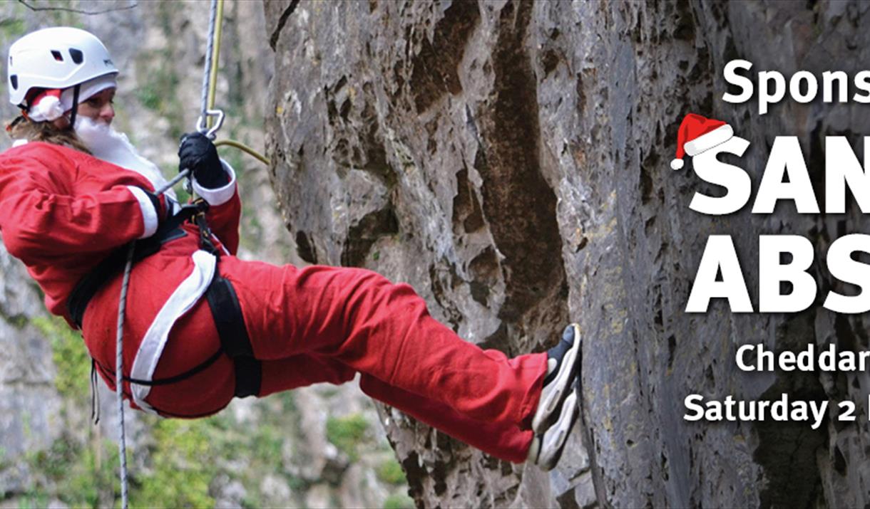 Santa abseiling down a rockface