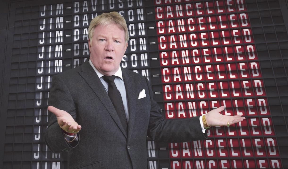 The background is the title repeating with the Cancelled highlighted in red, with Jim Davidson in front.