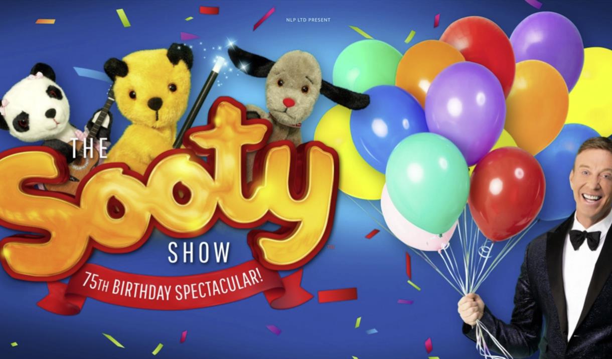 Sooty and friends on the left and Richard on the left holding balloons.
