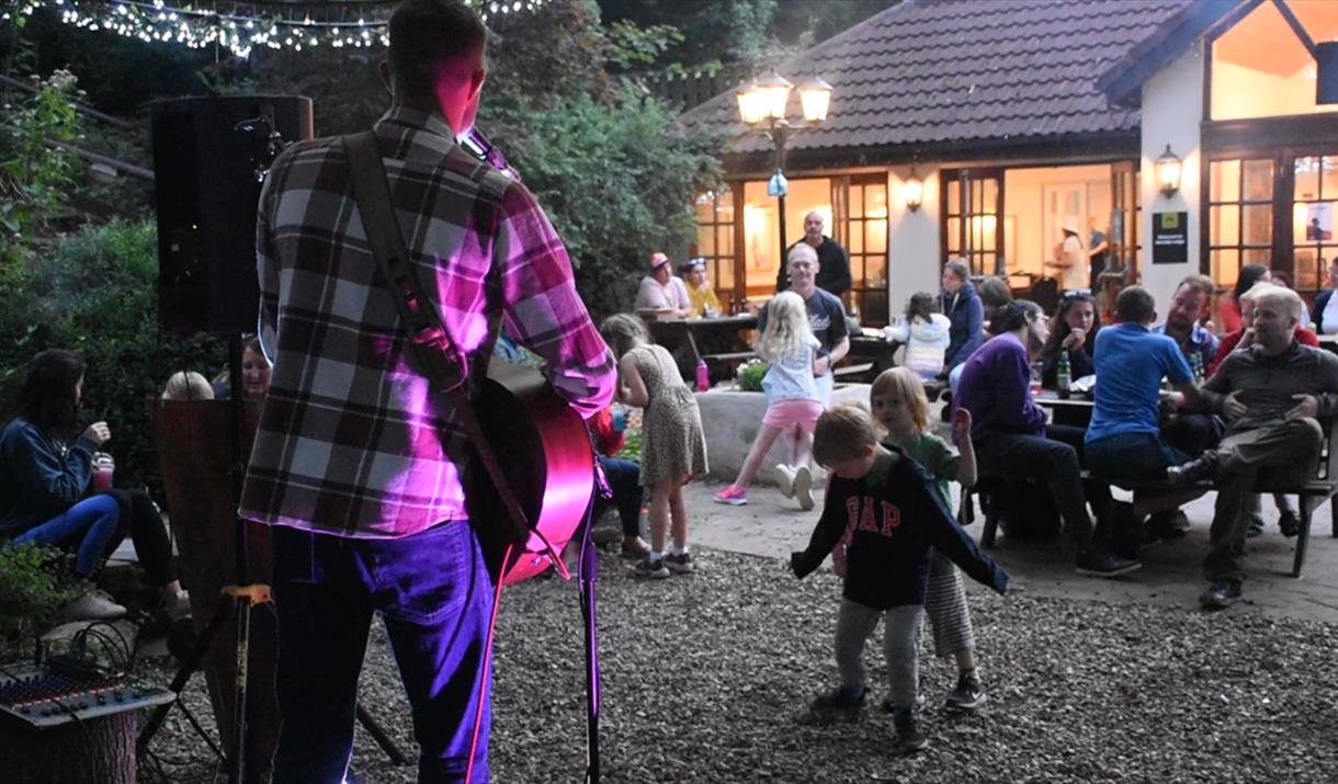 Sam Evans on stage  with children dancing in front