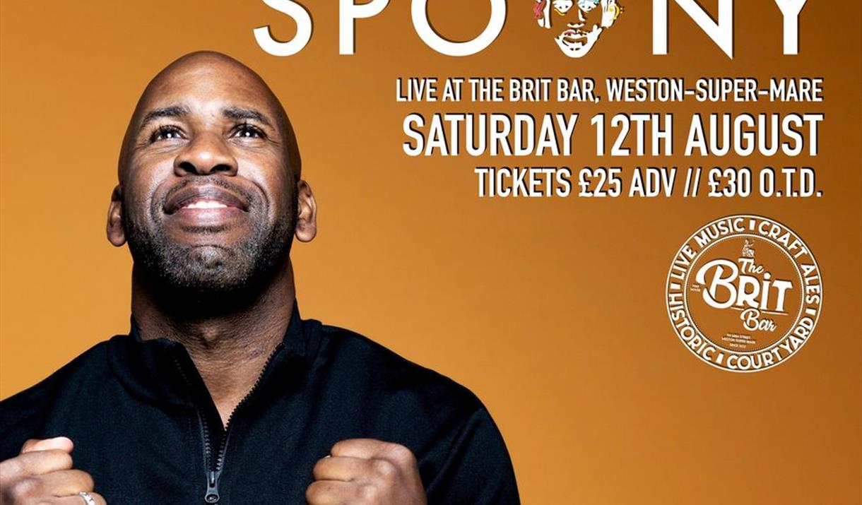 Mug shot of DJ Spoony looking upwards with his clenched fists down by his chest.