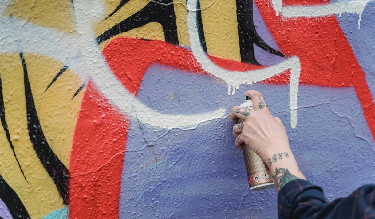 Person with spray can performing street art