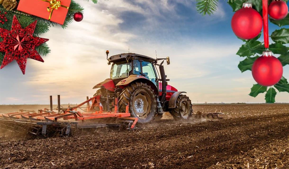 Image of a red tractor and machinery working on a ploughed field with festive items at the top of the picture