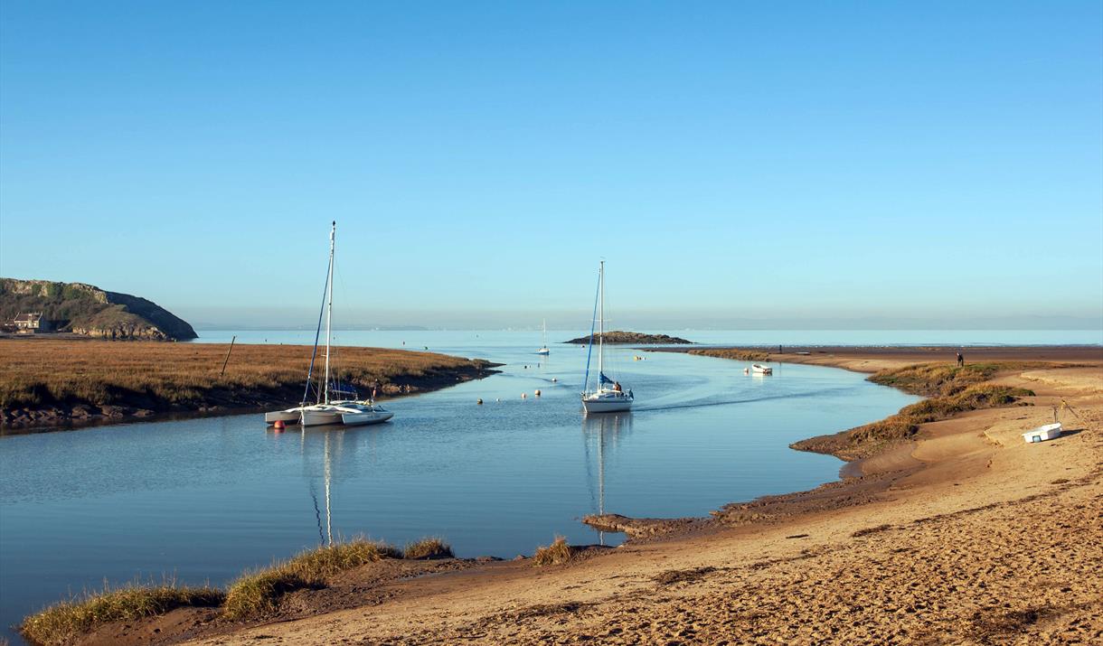 Uphill Beach and estuary near Weston-super-Mare. The image shows the sandy beach, boats in the estuary and a small island at the mouth of the estuary