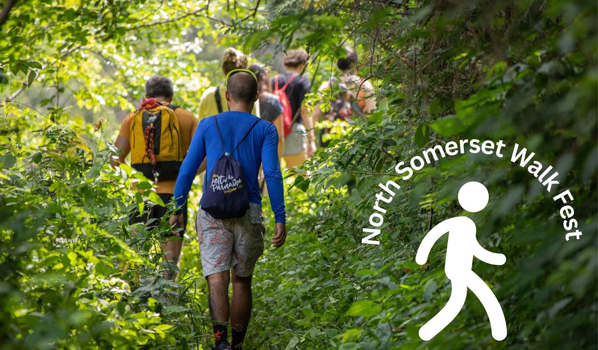 A group of ramblers on a narrow wooded footpath