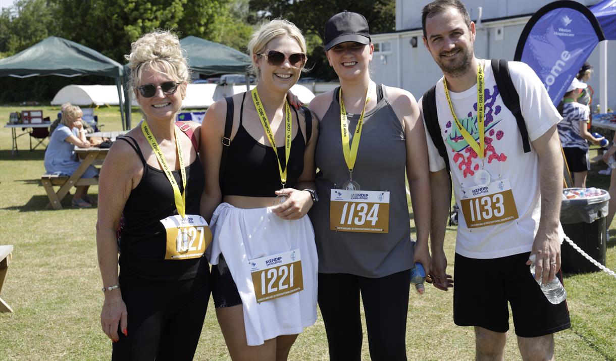 Mendip Challenge participants with their medals and walking numbers stood at Weston Cricket Club.