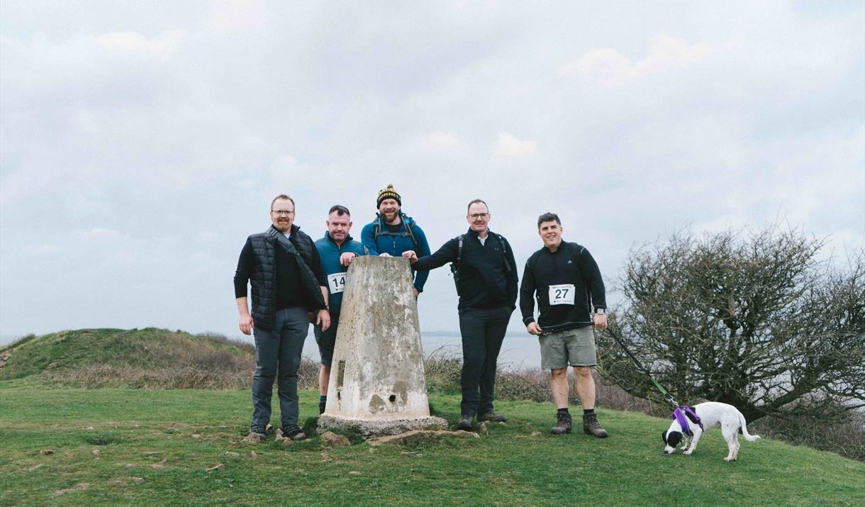 Five men at Sand Point, one with a dog on a lead