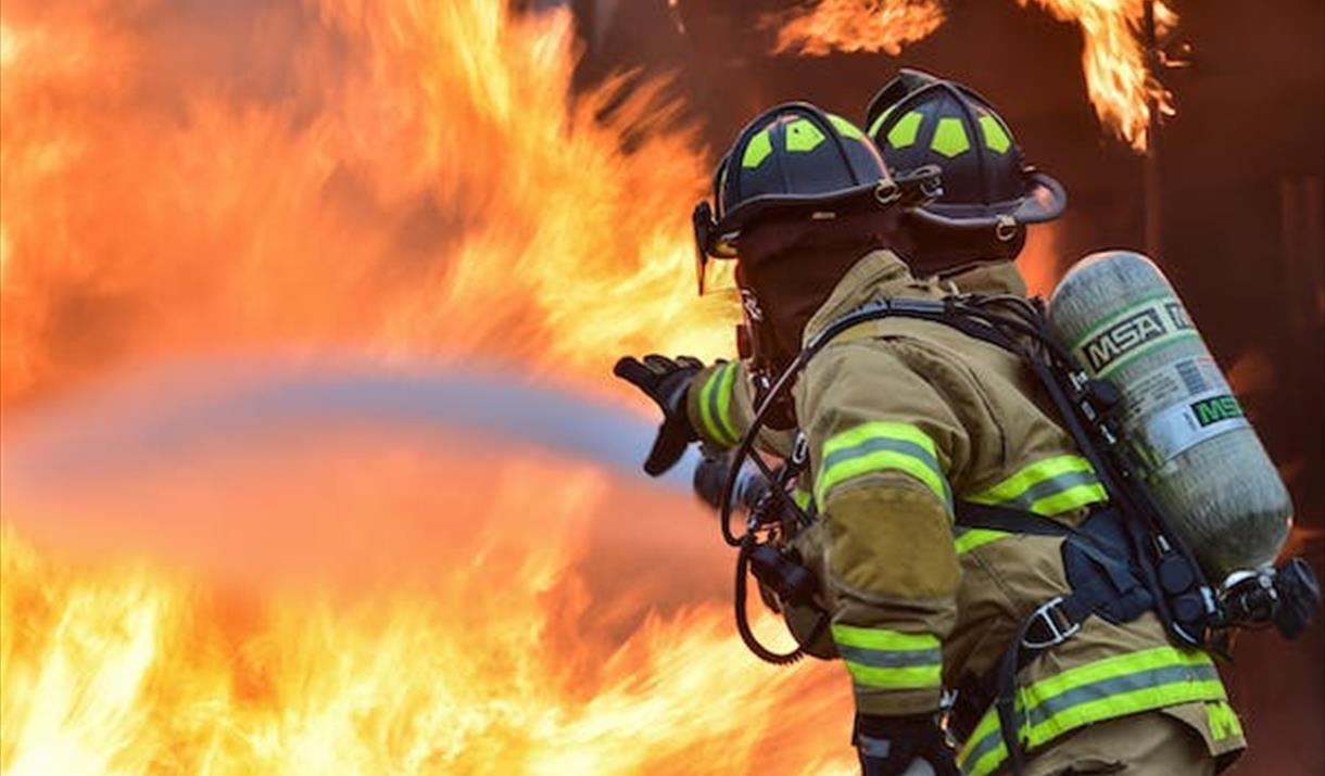 Two firefighters tackling flames