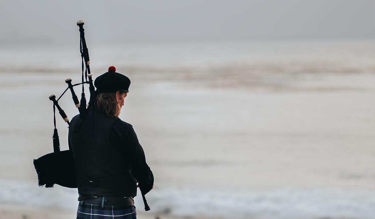 A bagpiper on the beach