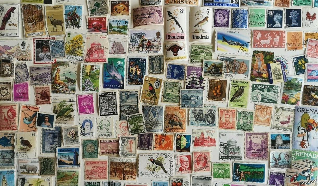 Photograph of stamps from all over the world in various colours and sizes.