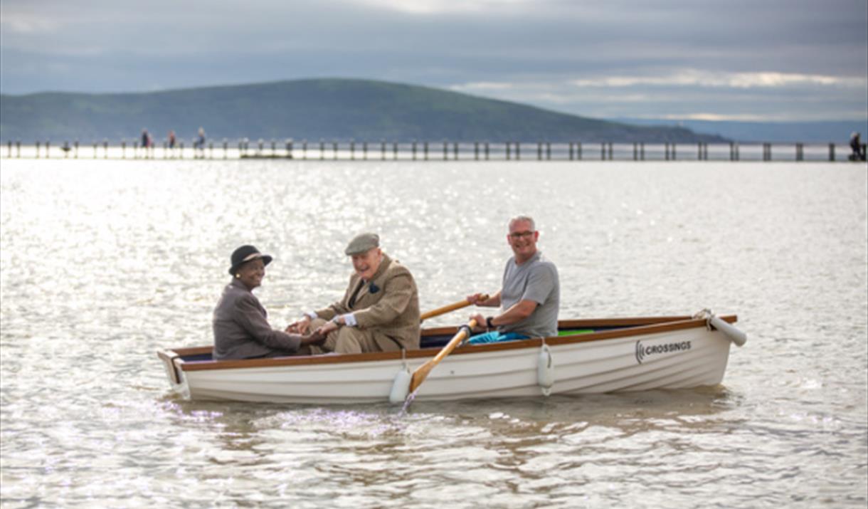 Three men in a row boat on a lake.