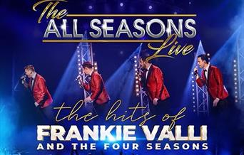 Four performers from the group All Season on stage singing and wearing red jackets