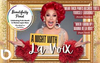 La Voix smiling as she appears from a golden photo frame