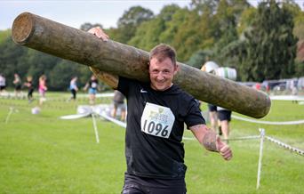 Competitor carrying a large log on his shoulders