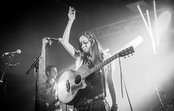 Black and white picture of the artist with guitar