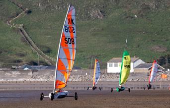 Four land yachts racing cross the sand at Brean Beach