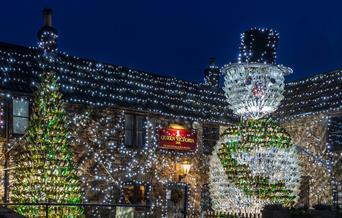 The Queen Victoria pub in Priddy and its famous Christmas Lights display featuring a giant 26ft tall snowman made out of 2,500 empty wine bottles and