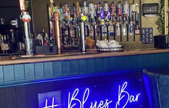 Photograph of the Blues Bar bar with electric blue signage
