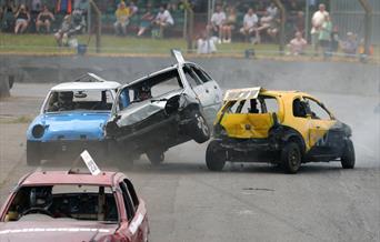 A banger racing car sandwiched between two other banger racing cars