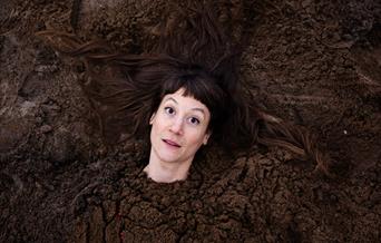 A person's head. Their body has been buried in soil