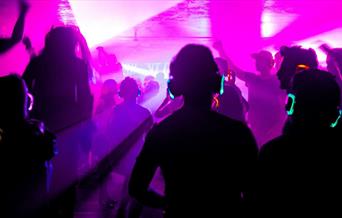 People wearing headphones and dancing at a silent disco