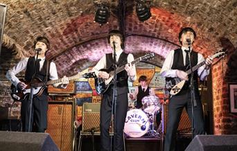tribute band on stage, singing into mics