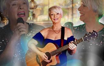 Singer Lorraine Lee wearing a blue dress and playing a guitar in front of a banner featuring two images of her