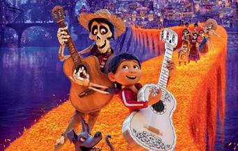 The poster for the film Coco which features and child and a skeleton playing a guitar. The characters in the background suggest the Mexican Day of the