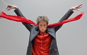 Photograph of Boorish wearing a bright red shirt and scarf.