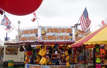 image shows fairground attractions, teddy bear stand