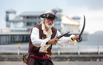 A pirate with a sword and gun outside The Grand Pier at the Weston-super-Mare Sea Shanty Festival