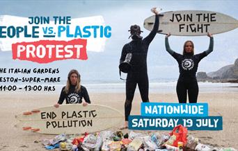 A pile of litter on a beach with three people wearing wetsuits behind it.  The lady on the left kneeling and holding a surfboard in front of her with