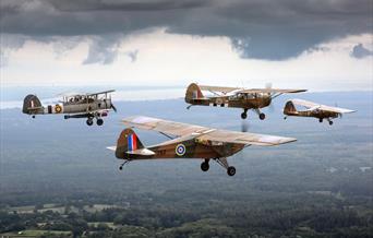Four vintage military aeroplanes flying in formation