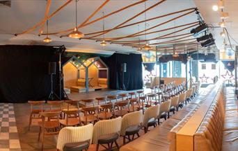 Interior image of a fringe theatre taken from the back looking over seats towards the stage