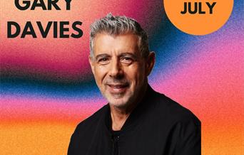 Mug shot of DJ Gary Davies against a colourful backdrop