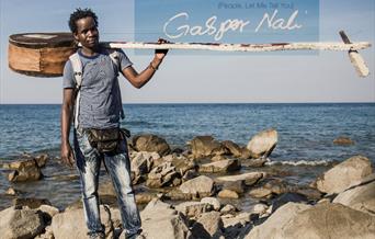 Gaspar Nali on rocky beach with percussion instrument