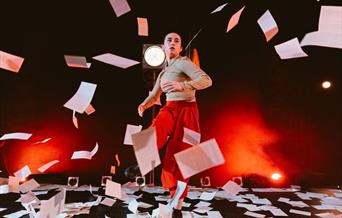 person moving through flying sheets of paper