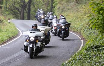 A procession of Harley Davidson motorbike riders driving into Weston-super-Mare from Sand Bay