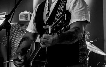 Black and white photograph of Steve Mitchell playing the guitar