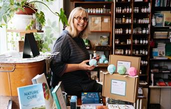Photograph of Poet, Deb Alma, sat in a book shop.