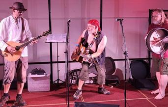 Brian Stone and band performing on stage with guitars and drums