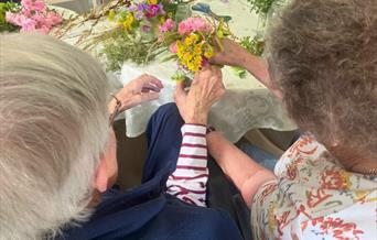 Two people arrange flowers