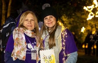 Moonlight Memory Walkers poster - two ladies wearing lights and memory walk t-shirts.