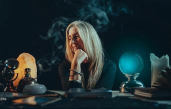 Photograph of Melanie sitting at desk with crystals.