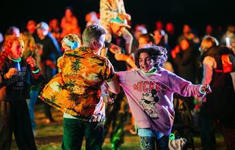 A male and female dancing in the crowd at the Mendip Family Festival
