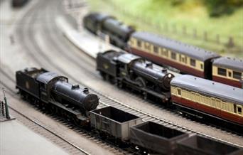 Three model steam trains on a model railway set