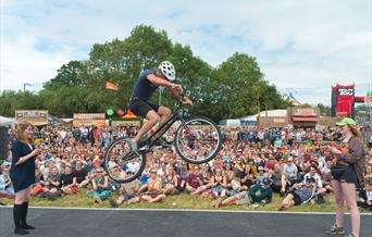 A mountain bike stunt rider jumping over a tightrope