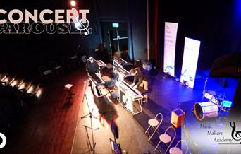 The Concert Carousel promo image of instruments on a stage with blue lighting.