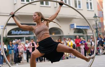 A woman balanced on a large hoop