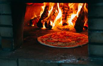 Enjoy tasty wood-fired pizzas